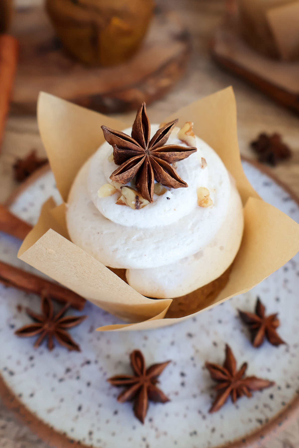 Pumpkin muffin with cream cheese frosting on plate.