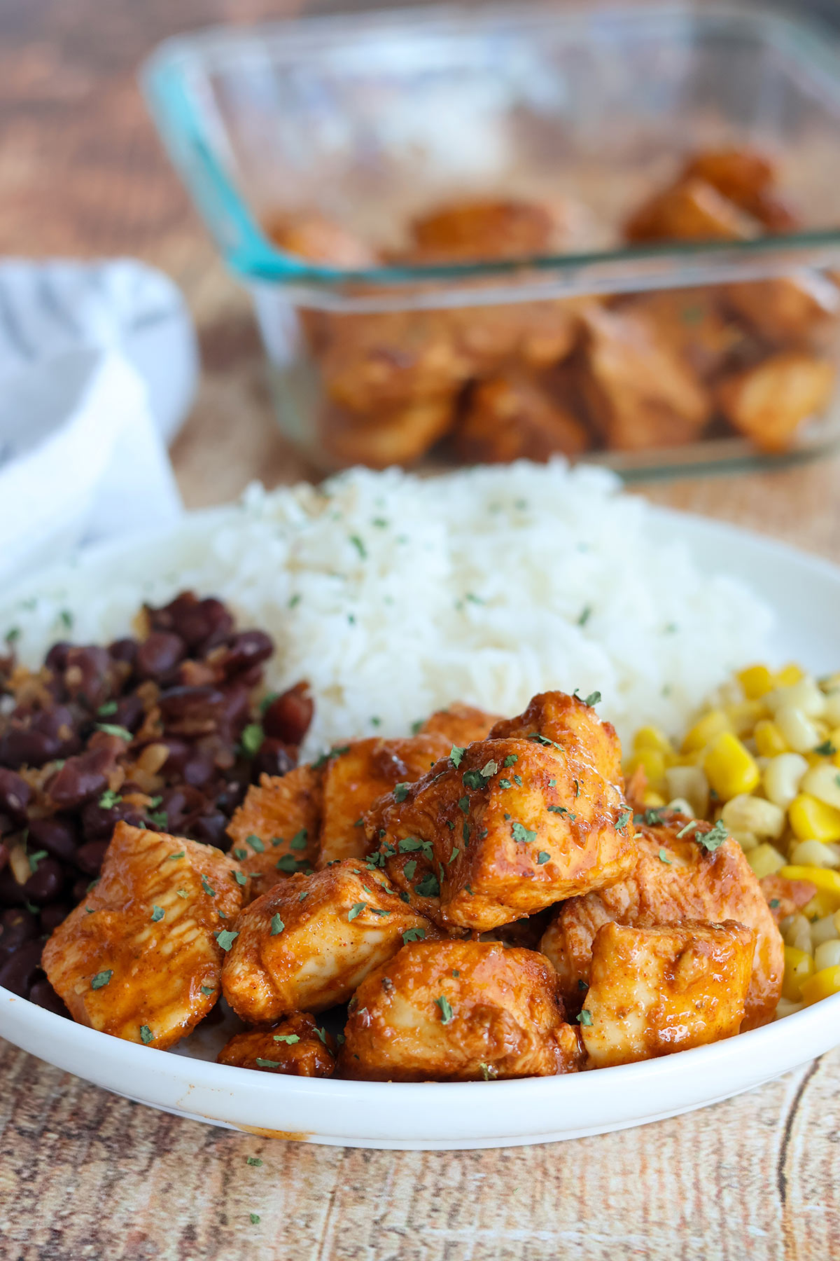 Plateful of chicken bites with beans, corn, and rice.