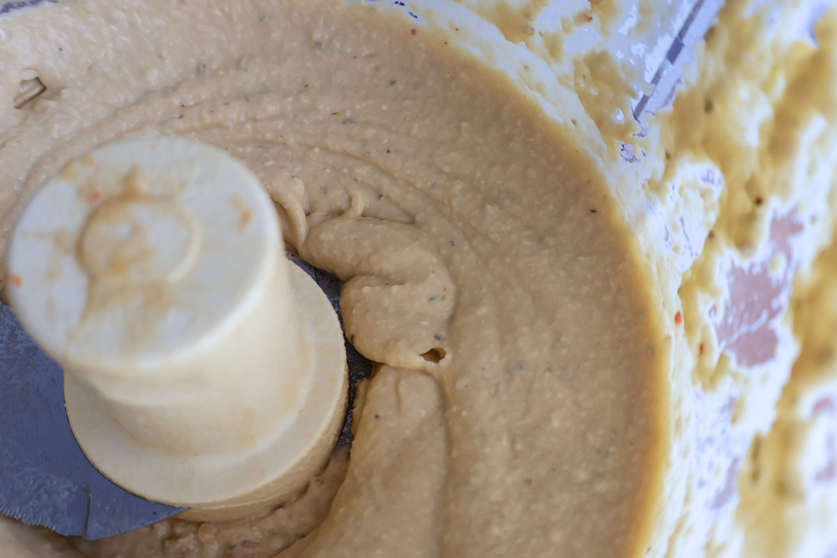 Food processor with blended hummus.