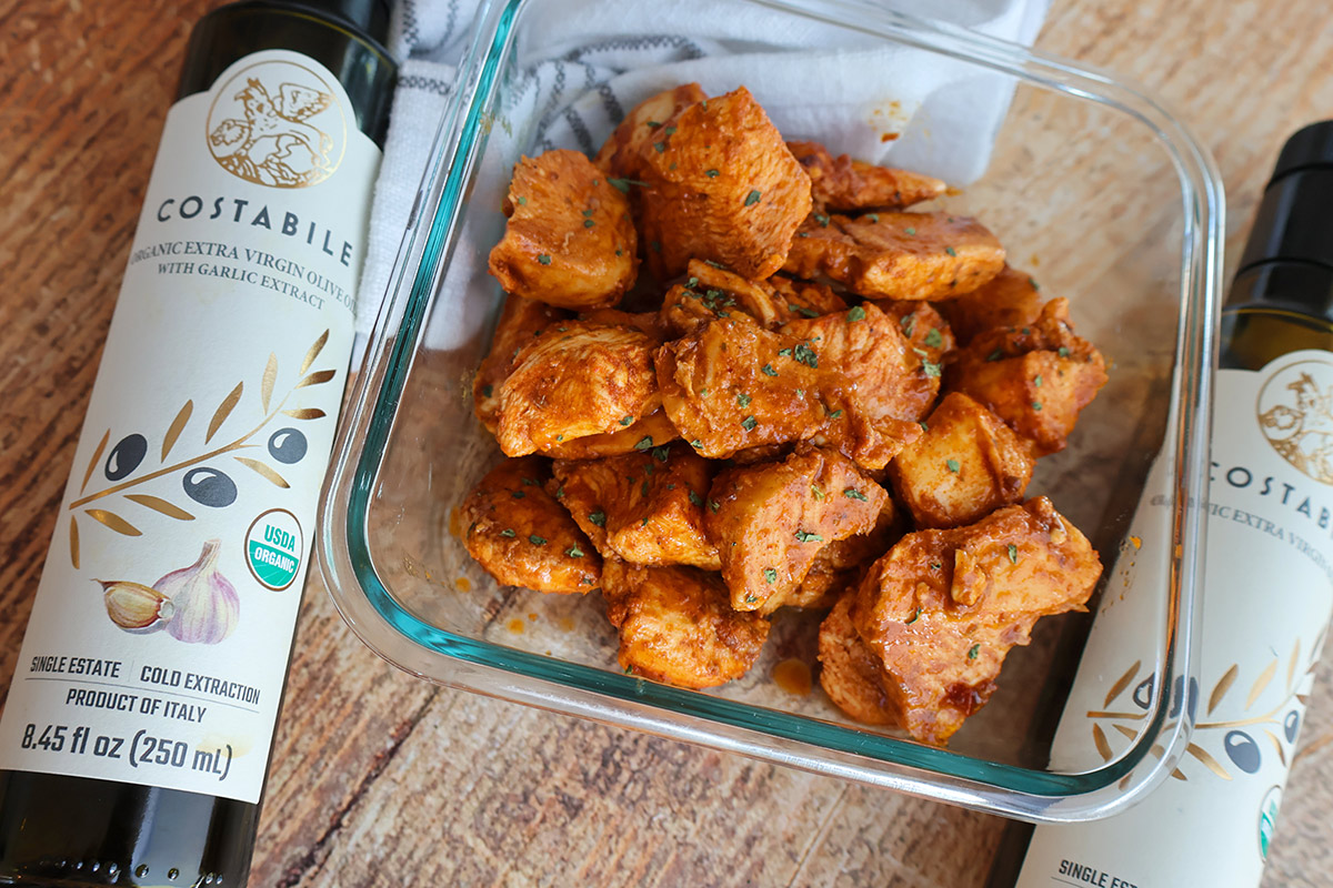 Overhead shot of dishful of chicken chunks next to bottles of olive oil
