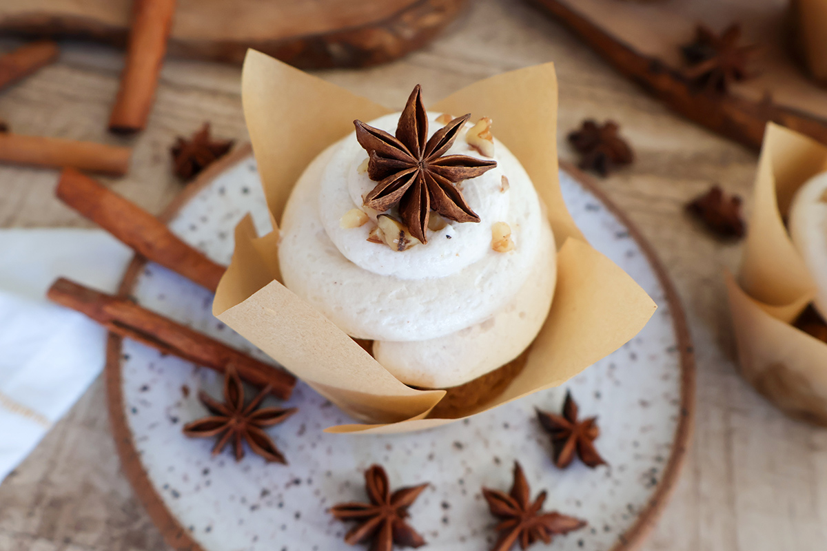 Frosted pumpkin muffin on plate.