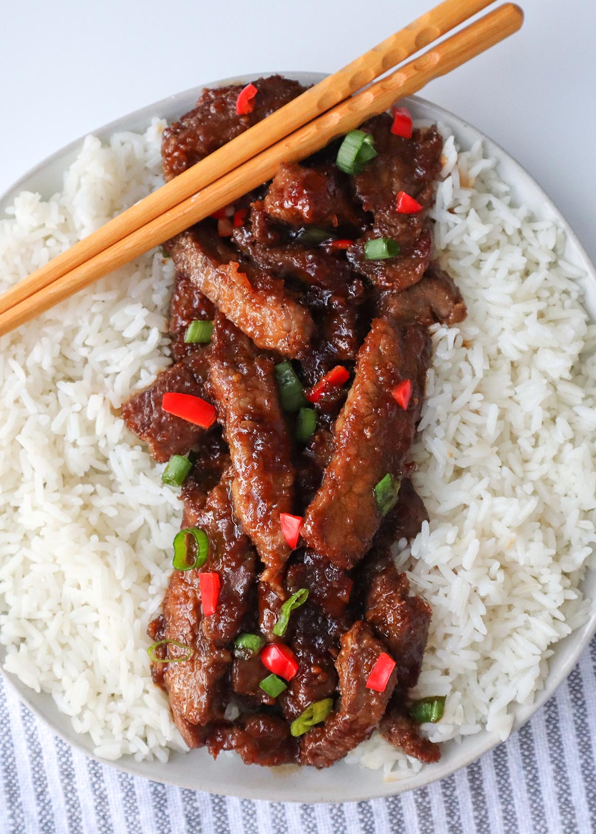 Overhead shot of Mongolian beef with rice on plate.