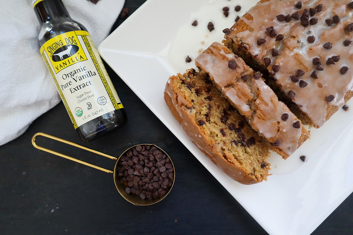 Overhead shot of plate with chocolate chip bread next to bottle of oil and chocolate chips.