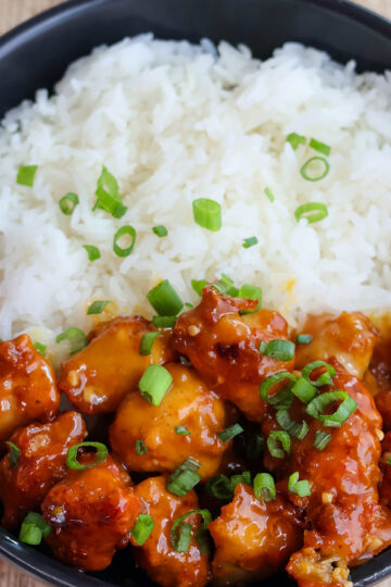 Overhead shot of bowlful of orange chicken with white rice.