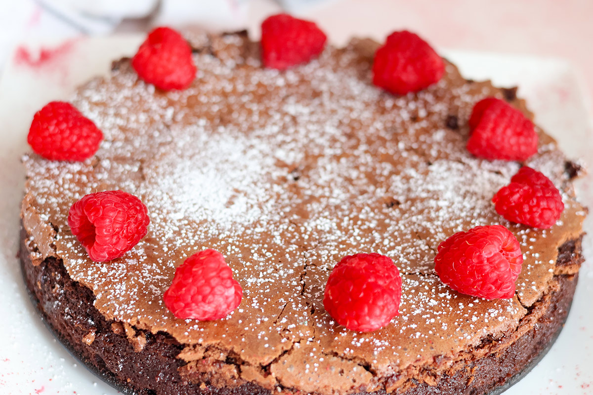 Whole Passover chocolate cake decorated with berries.
