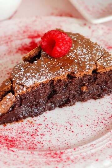 Slice of flourless chocolate cake on plate.