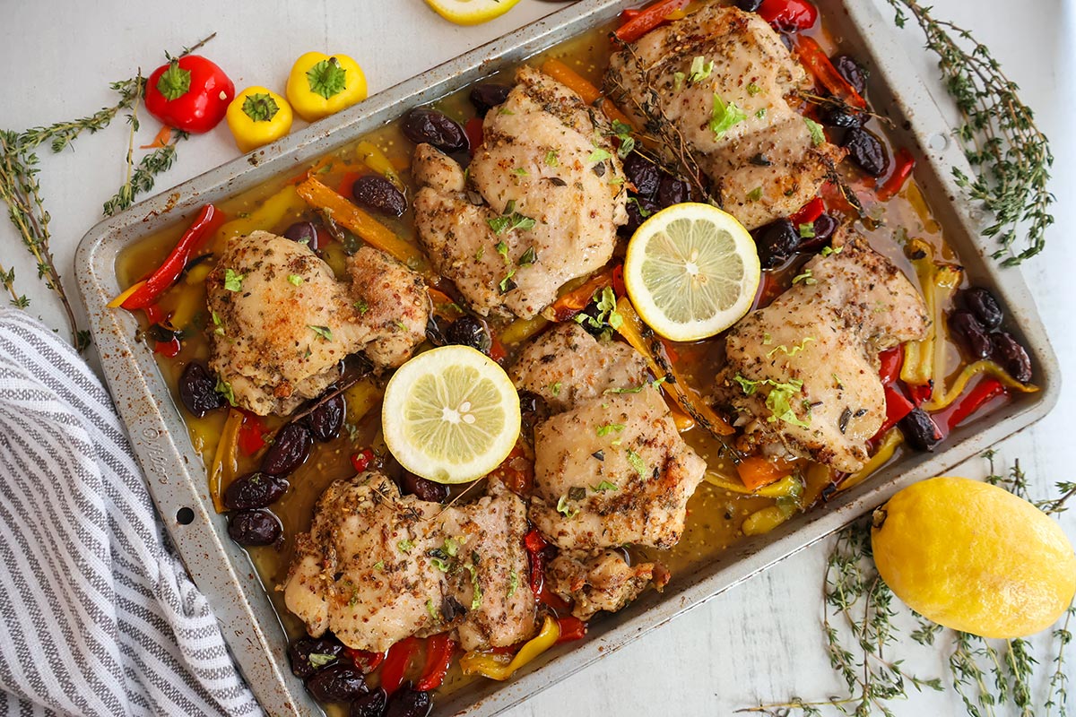 Sheet pan full of baked chicken thighs and vegetables