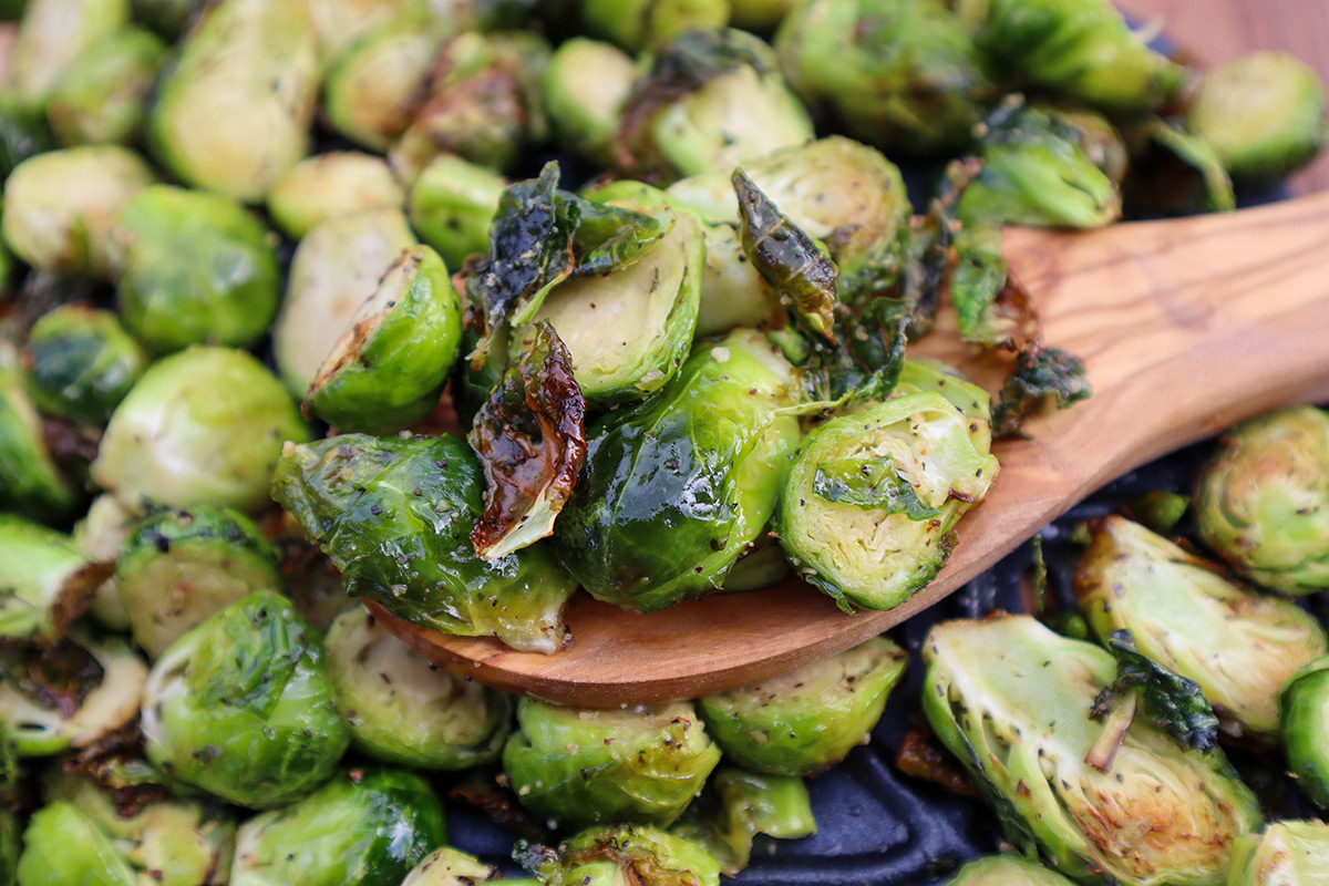 Closeup shot of wooden spoon with cooked brussel sprouts.