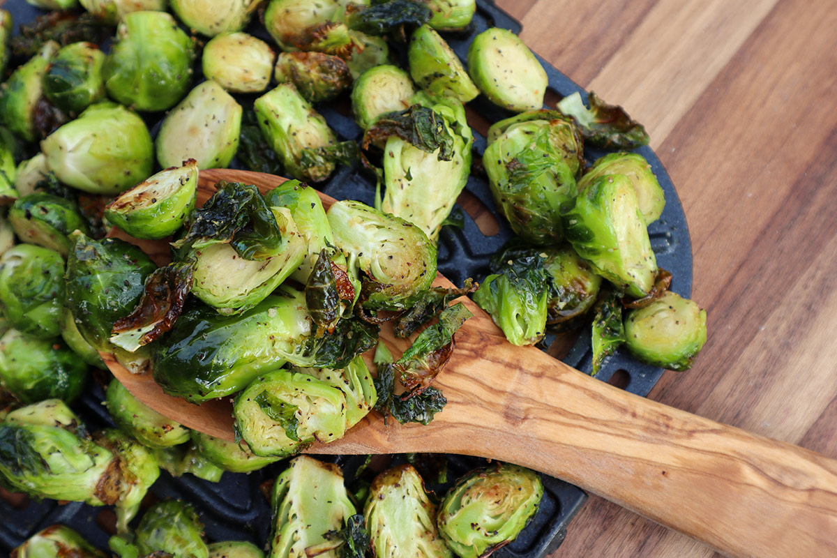 Overhead shot of caramelized brussel sprouts on air fryer tray.