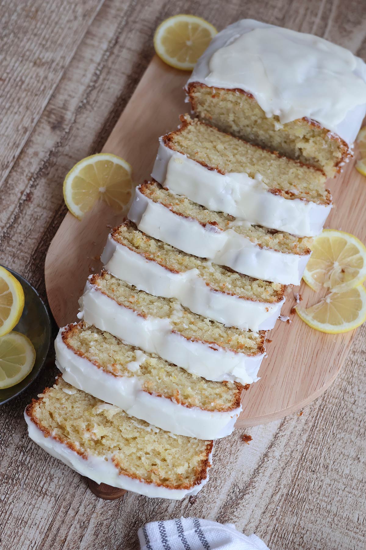 An overhead shot of a sliced frosted lemon pound cake. 