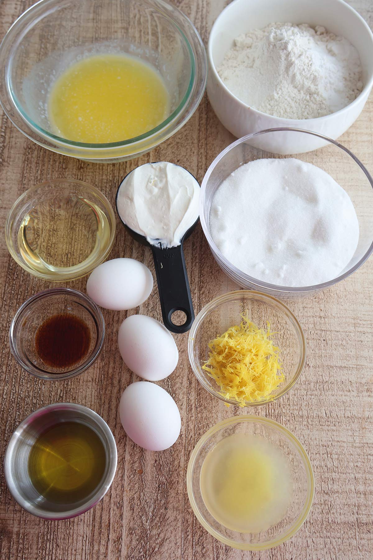 An overhead shot of individual lemon pound cake ingredients in bowls. 