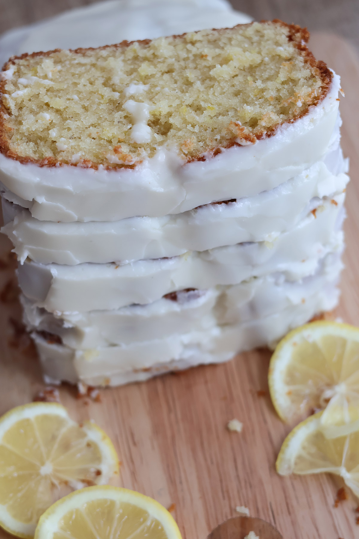 Slices of frosted lemon cake stacked atop one another. 
