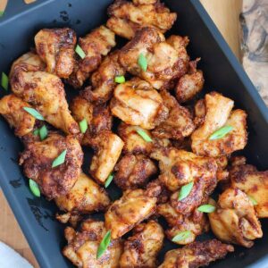 Golden air fried chicken bites in a blue baking dish.