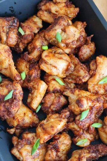 Golden air fried chicken bites in a blue baking dish.