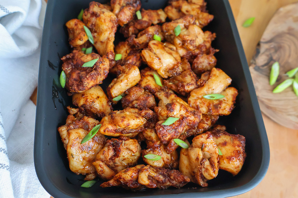 Crispy, golden chicken bites in an air fryer basket.
