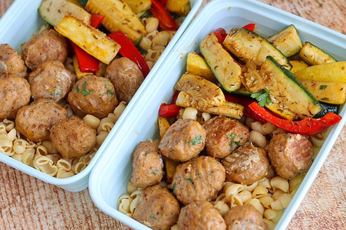 Meatballs and red peppers in two plastic containers. 
