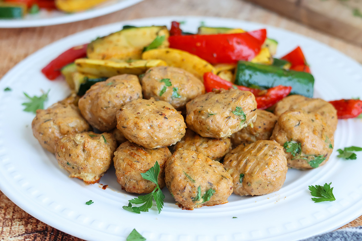 Air-fried turkey meatballs and peppers on a white plate.