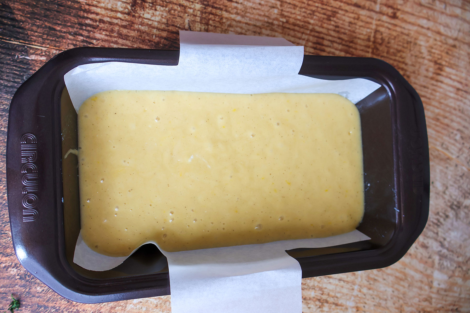 Lemon loaf cake batter in a metal loaf pan.