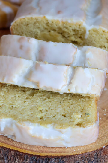 A sliced lemon loaf cake on a wooden board.