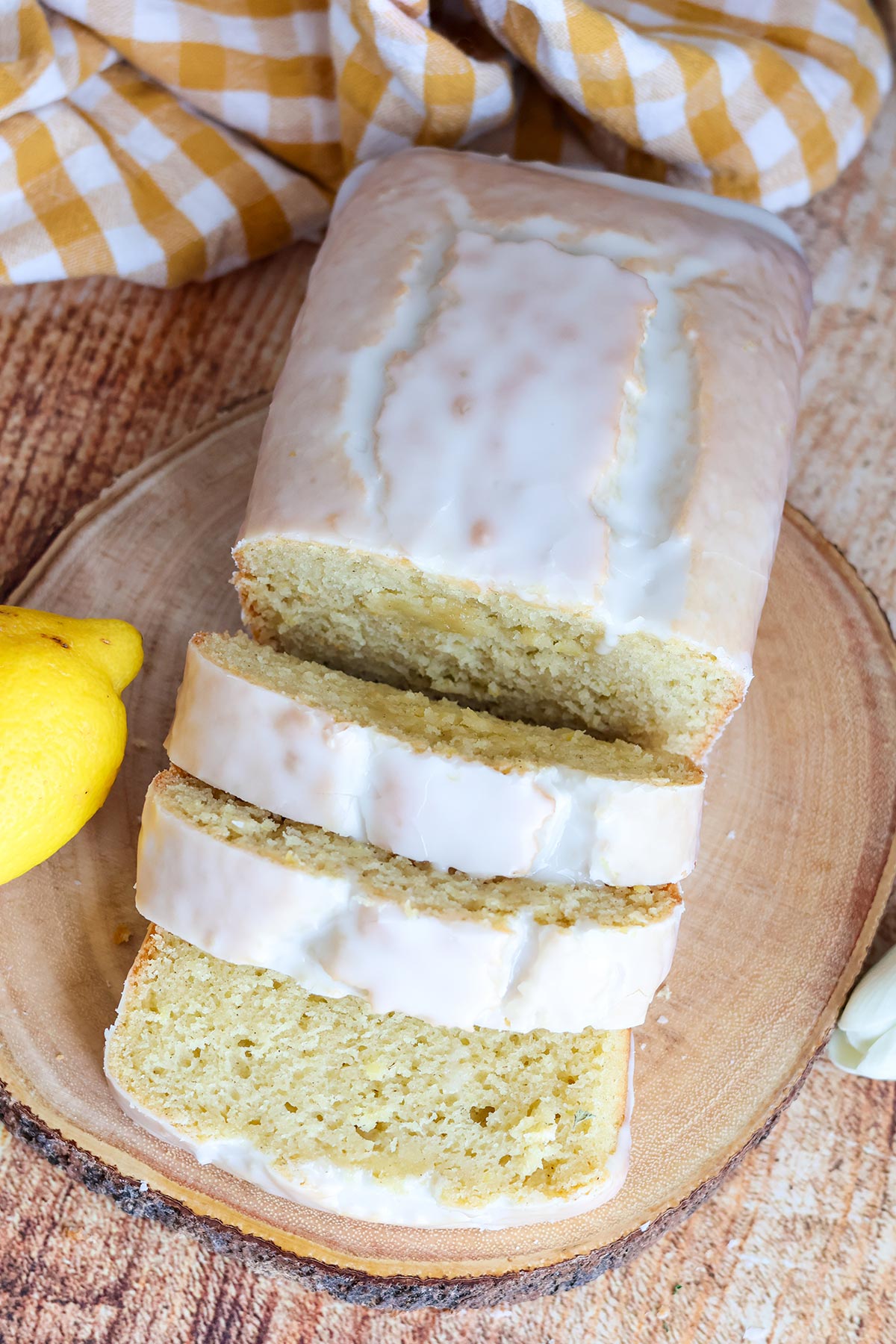 Sliced lemon loaf cake on a wooden board.