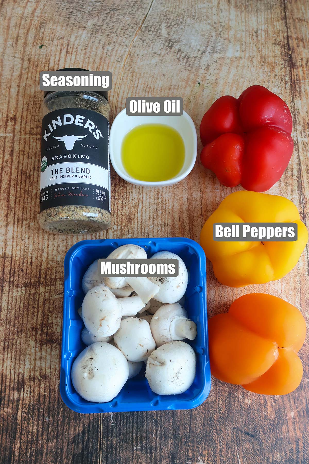 A package of mushrooms, three peppers, seasonings, and oil on a table.