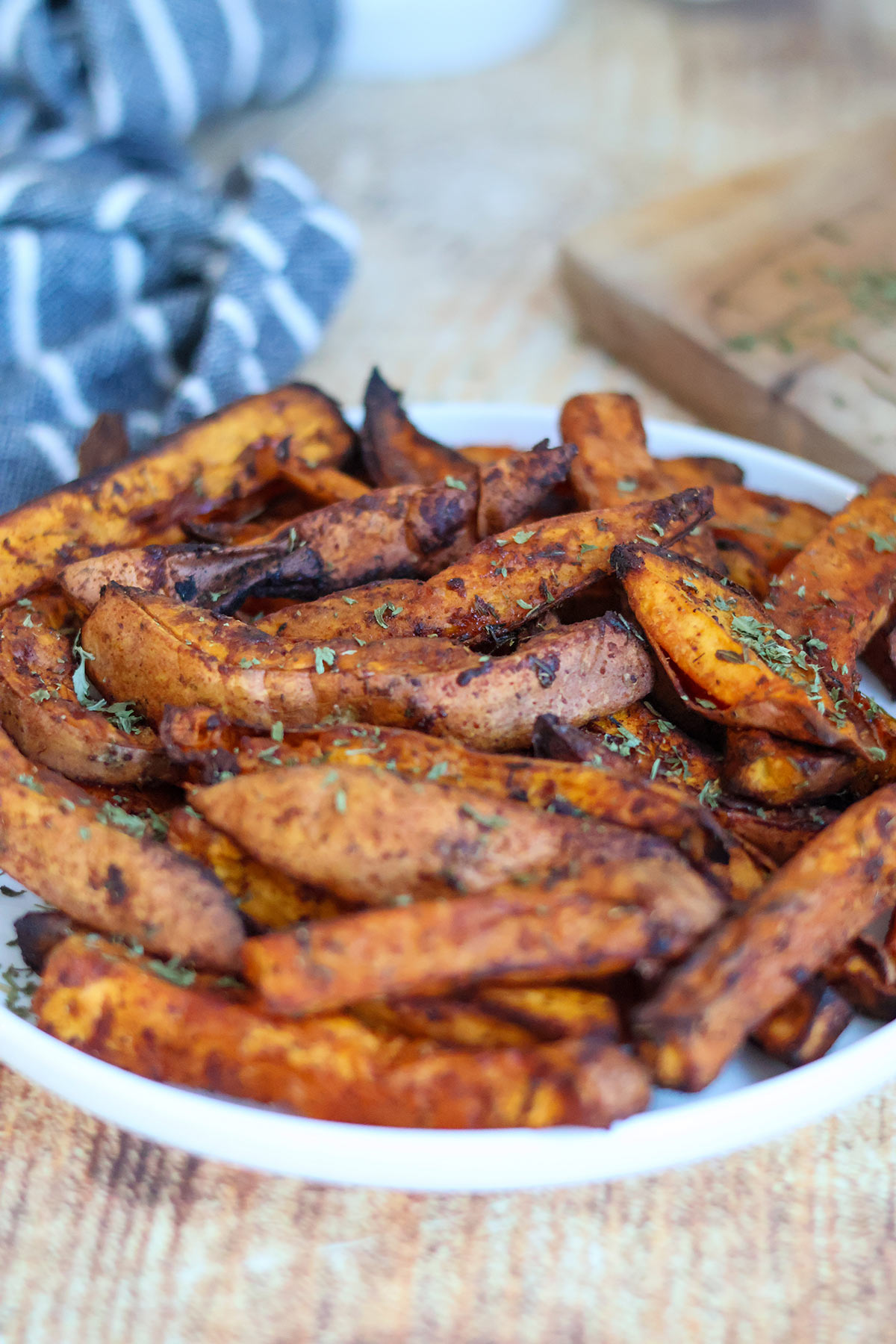 Crispy sweet potato wedges on a white plate.
