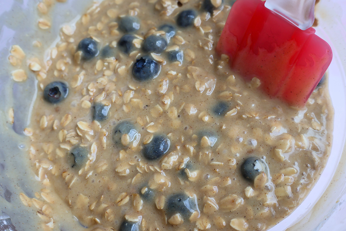 Blueberry muffin batter in a glass bowl.