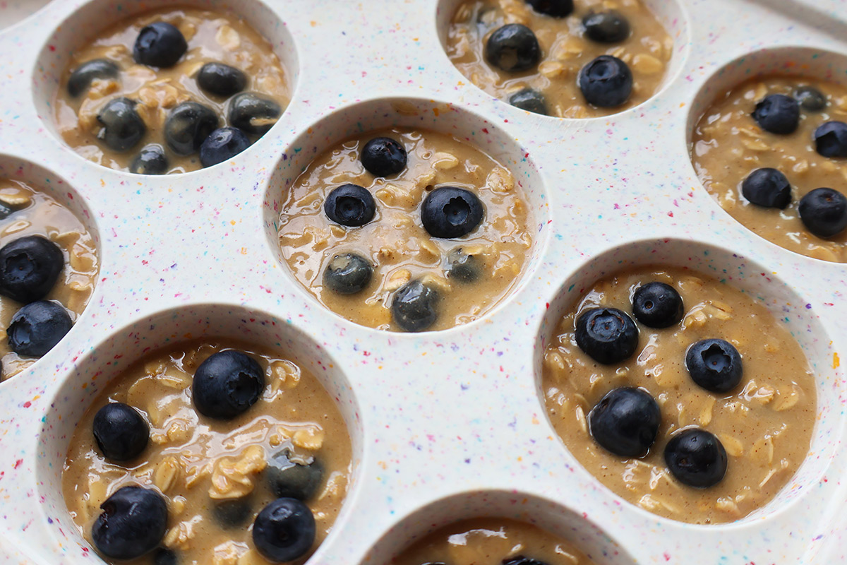 Blueberry muffin batter in a cupcake pan.