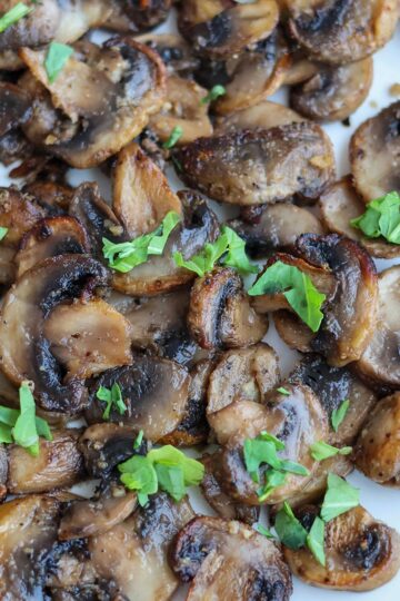 Tender air-fried mushrooms on a white plate.
