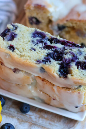 Three slices of lemon blueberry cake on a white plate.