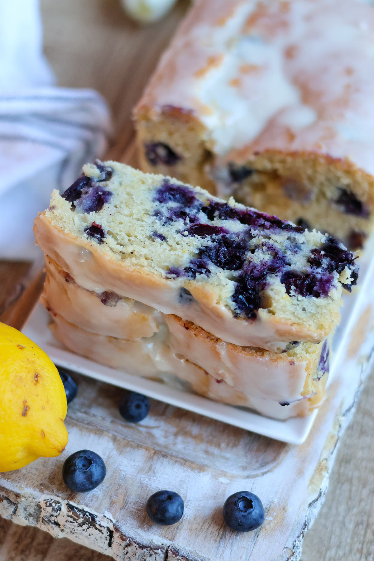 Three slices of lemon blueberry cake on a white plate.