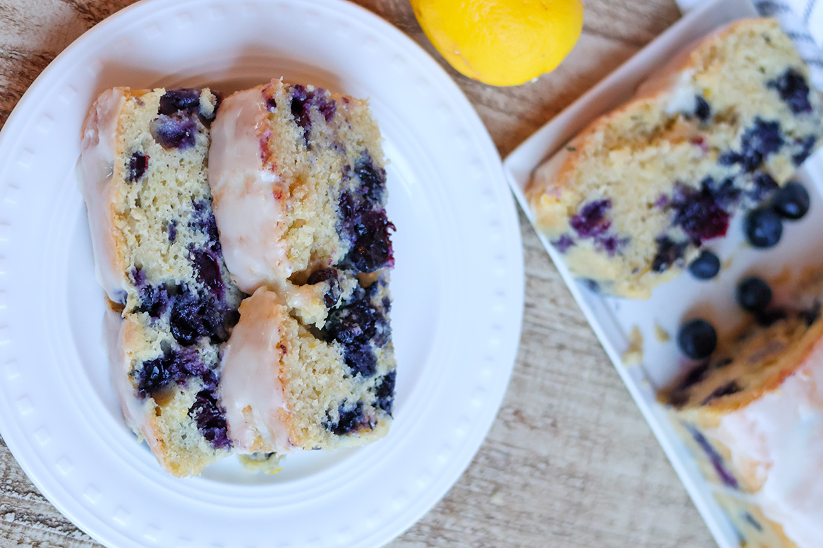 Two slices of blueberry loaf cake on a white plate.