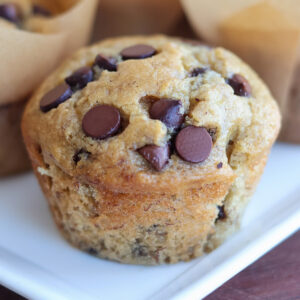 A chocolate chip banana muffin on a plate.