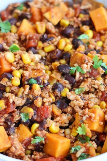 A white bowlful of Tex-Mex chicken sweet potato hash.
