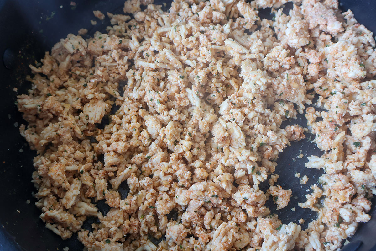 A skillet full of browned ground chicken.