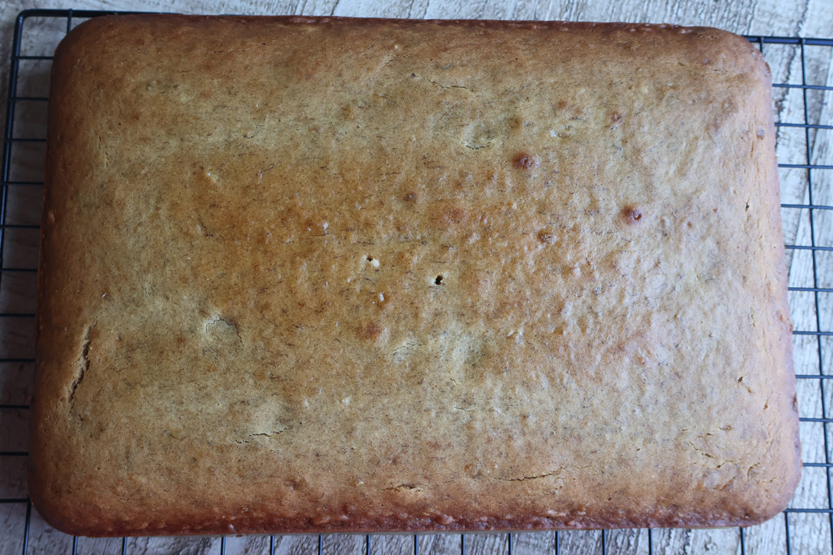 Baked whole banana cake on a wire cooling rack. 