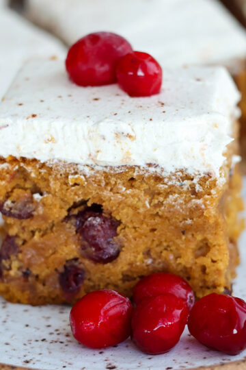 A slice of frosted pumpkin cake on a plate.