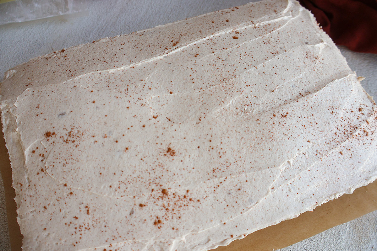 A frosted cake on a white board.