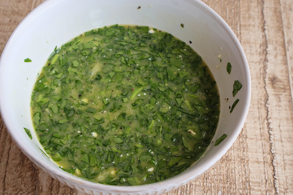 A bowlful of whisked eggs, spinach, and feta cheese.